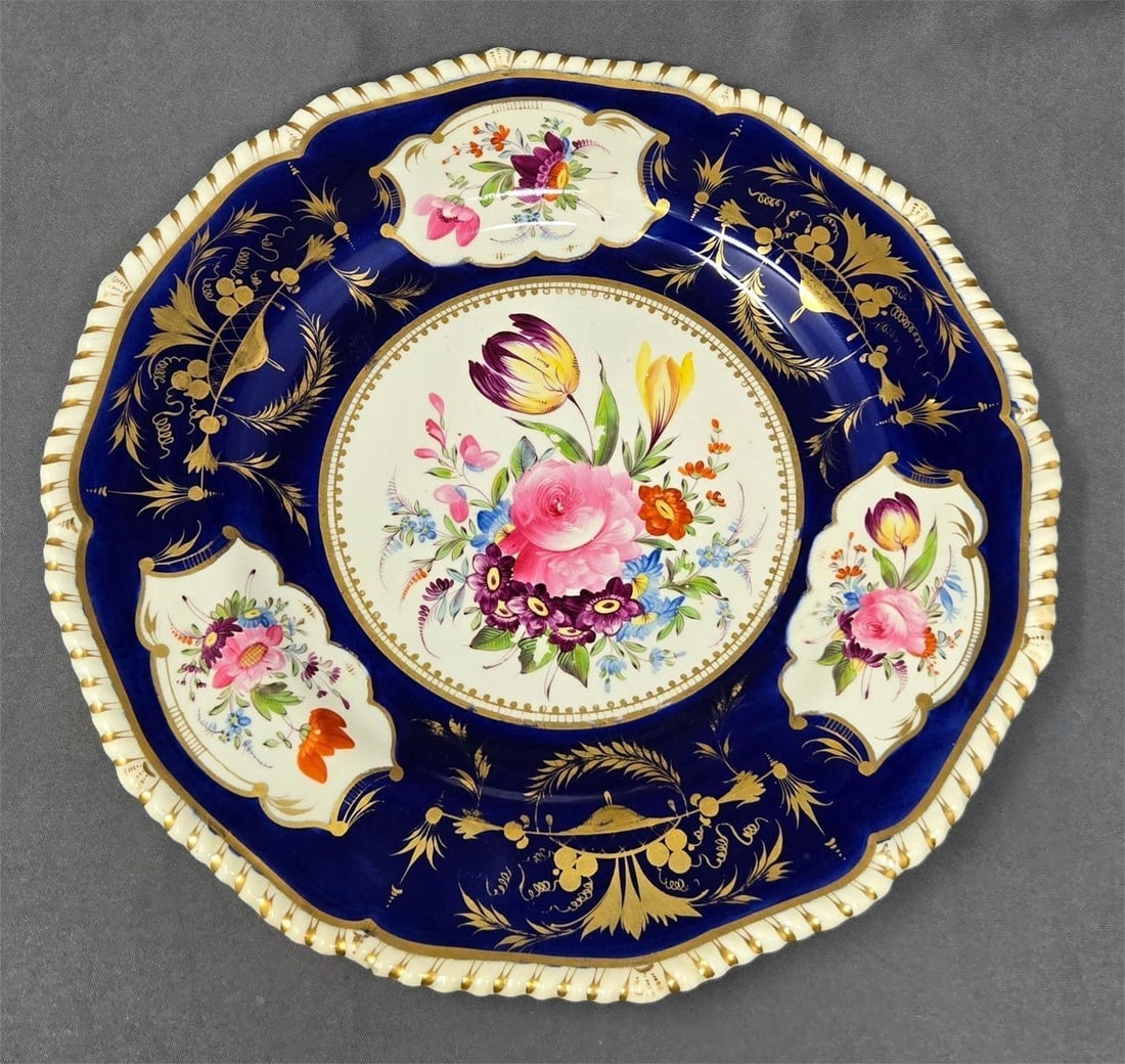 Old Derby Floral Decorated Dinner Plate c.1820s: Old Derby hand painted cobalt blue and floral decorated plate with gold accented rope border. Measures approximately 10 1/4 inches in diameter. It has a hairline crack and a small chip as shown. It al