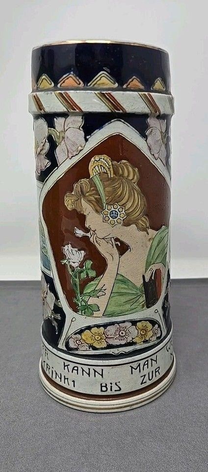 Matthias Girmscheid German Stein #932: Matthias Girmscheid Woman with Flowers pattern #932 stein. Etched pottery and threaded relief. It says in German, " One has to greatly admire the drinker who empties the stein down to the nail pegs."