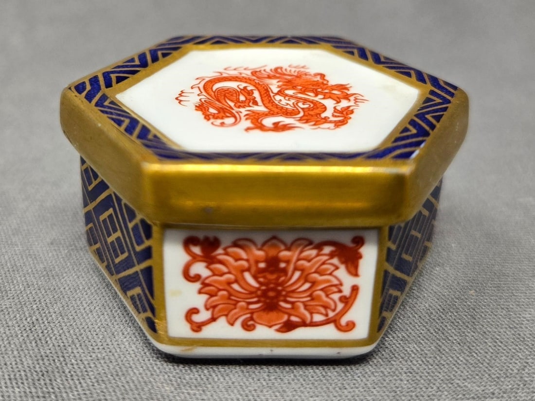 Royal Crown Derby Pill Box Pattern 1295 Red Dragon: Royal Crown Derby Imari style Red Dragon hexagonal pill box, Pattern 1295. Measures approximately 1 inch tall and 1 5/8 inches across. No chips or cracks. We can offer packaging and shipping on this l