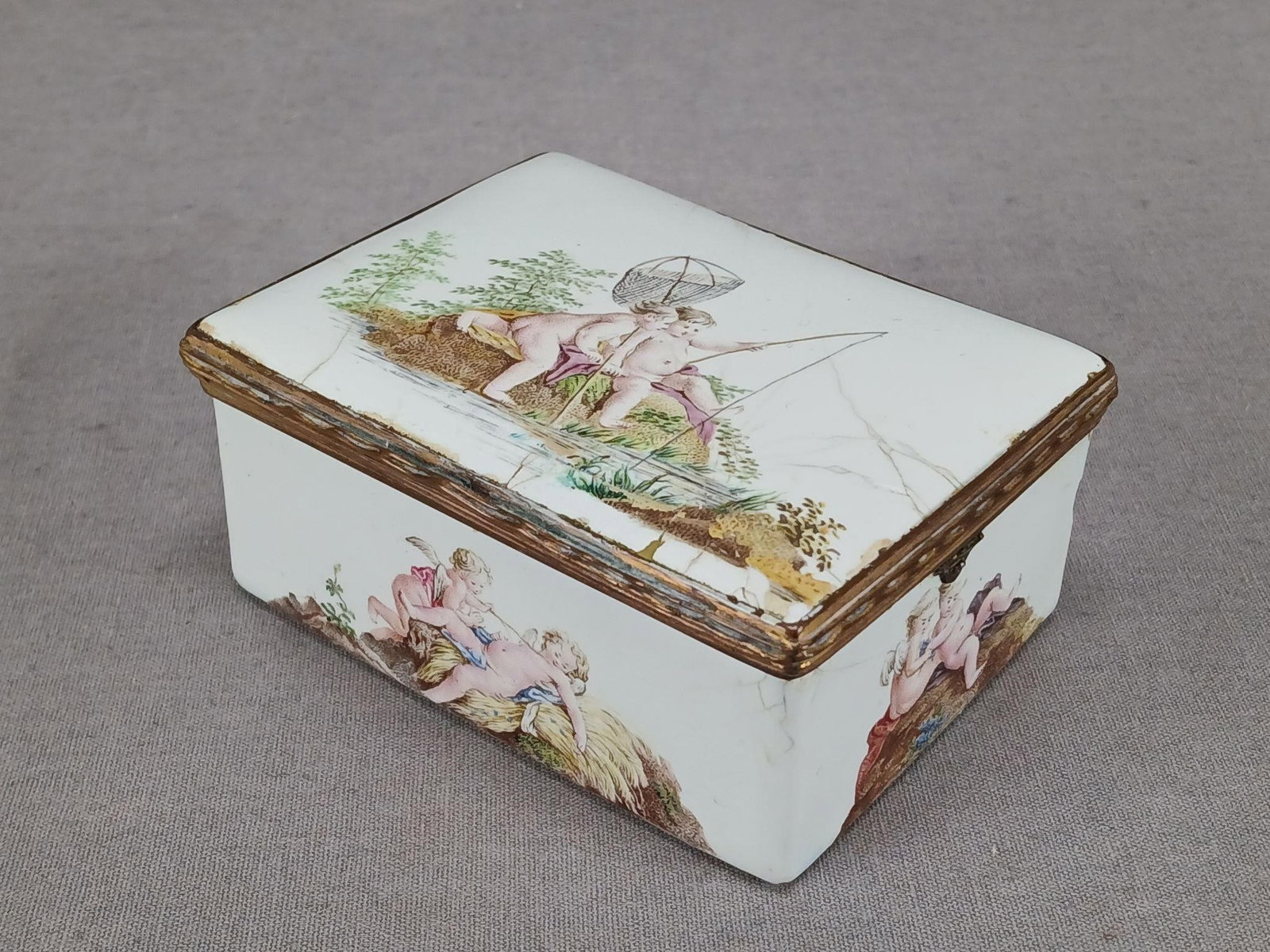 18th Century German Enamel Hand Painted Snuff Box: Antique mid 18th century German enamel snuff box. Decorated with hand painted putti / putto cherubs fishing on the lid, scenes of putto and winged cherubs on the sides and bottom of the box. Has a sce