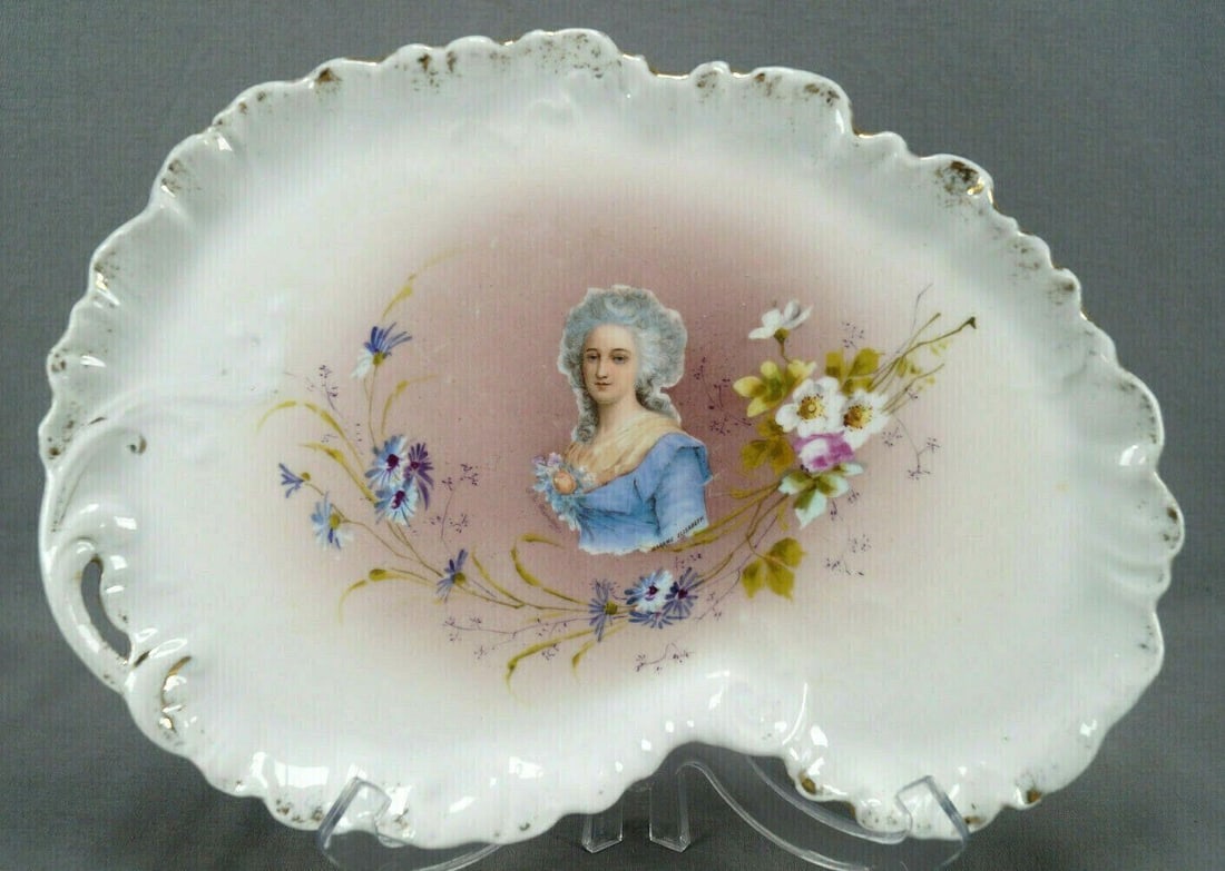 Limoges Madame Elisabeth Portrait Dresser Tray: Antique porcelain dresser tray. Decorated with a transfer portrait of Madame Elisabeth over pink. Framed by pink white, and purple flowers. With clouded gold gilding along the edge. Marked on the bott