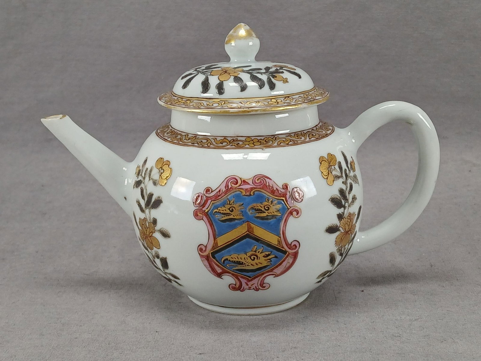 18th Century Chinese Armorial Dutch Market Teapot: Mid 18th century Chinese Export porcelain teapot made for the Dutch market. Decorated with a hand painted armorial crest in gold, blue, and pink and Grisaille type flowers with gold highlights. Gold s