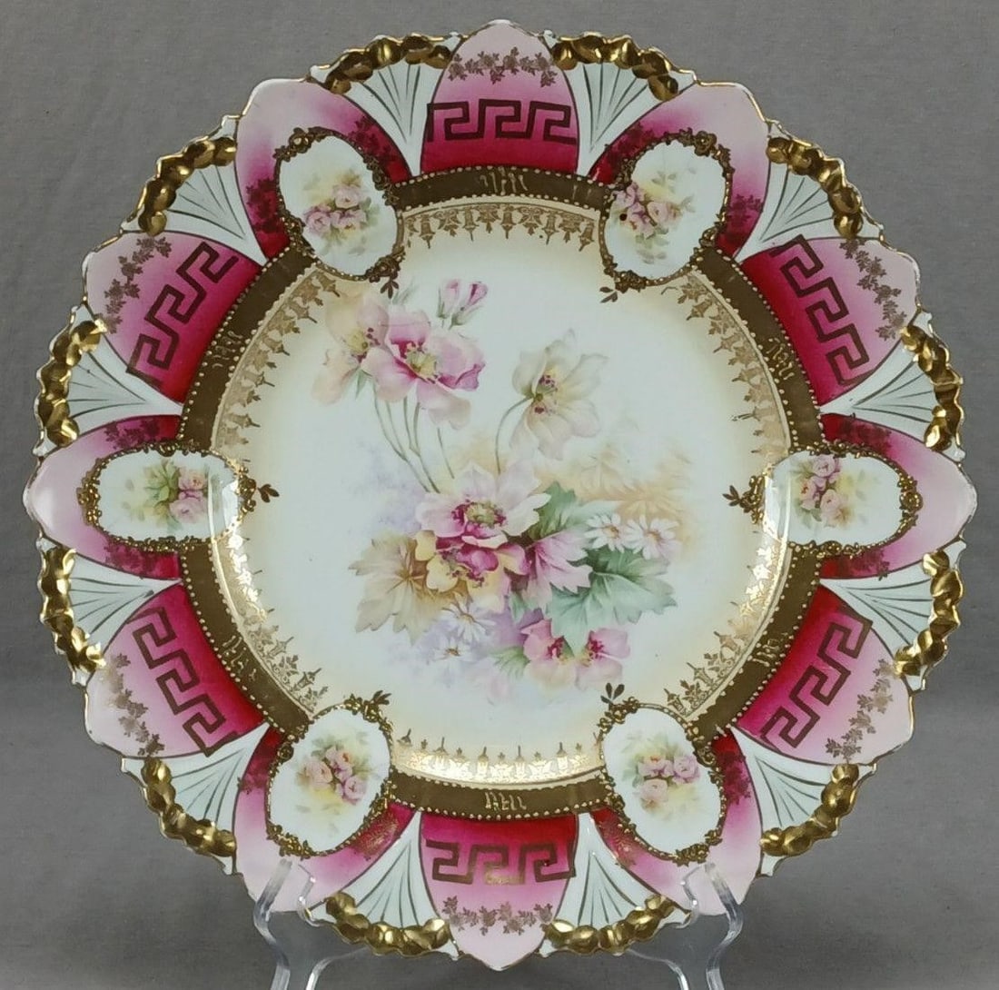RS Prussia Roses Cranberry Greek Key 12" Charger: Antique RS Prussia porcelain charger. Decorated with pink, white, and yellow roses and white daisies in the center over a pale yellow background. Has gold floral designs along the inner rim below a go