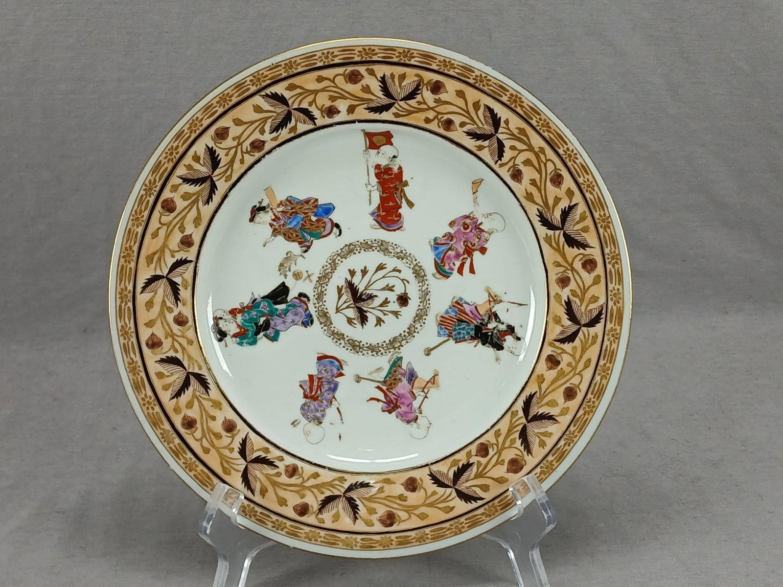 Japanese Arita Hichozan 8 5/8 Inch Plate A: Antique Japanese porcelain plate. Decorated with hand painted brown and gold berries and leaves in the center surrounded by Asian figures. Hand painted brown and gold berries and leaves around an apri
