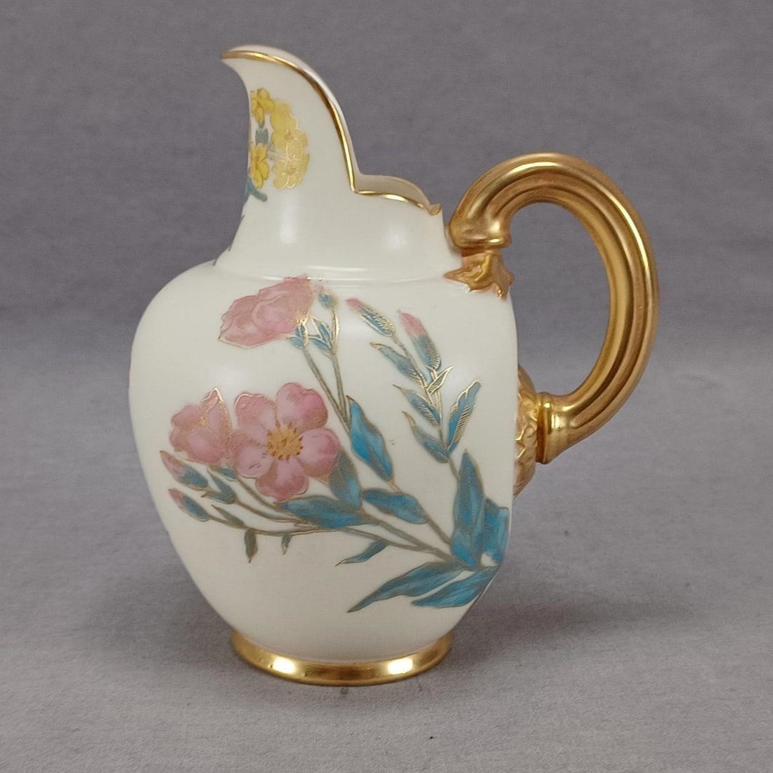 Royal Worcester Flowers Blush Ivory Creamer C.1889: Nice antique late 19th century blush ivory creamer or small jug. Decorated with hand painted pink, purple, and blue flowers with gold highlights. Gold gilding along the edge and to the handle. Marked 