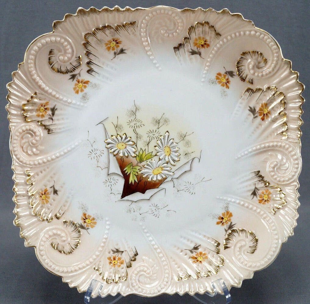 RS Prussia Mold OM10A Daisies Peach 10 7/8" Plate: Pretty porcelain plate in Mold OM10A with relief molded scrollwork beading and raised central white daisy flowers framed in gold gilding. With smaller orange flowers around the edge and gold gilt high