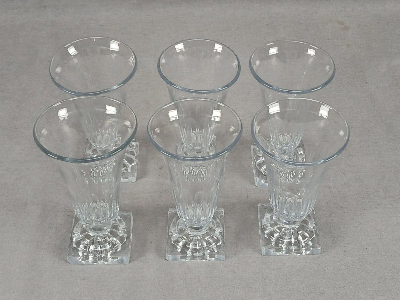 6 Anglo Irish Lemon Squeezer Base Jelly Glasses: Set of 6 antique 19th century blown and pressed Anglo Irish jelly glasses. Panel cutting to the bowl. Pressed lemon squeezer type base. Circa 1800. These all have numerous large and small chips to the
