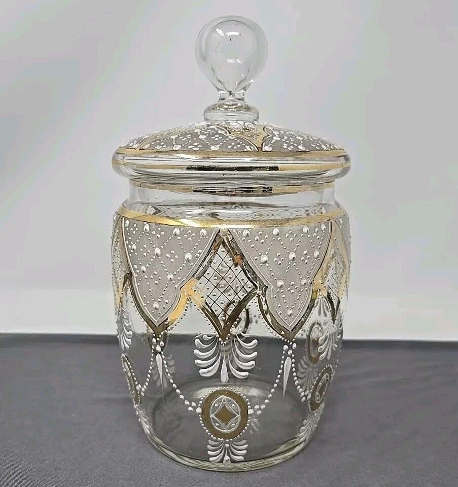Antique Bohemian Moser Style Enameled Biscuit Jar: Bohemian hand enameled with white beaded swags and gold gilt design. Stands 9 1/4 inches tall and 5 1/2 inches wide. No chips or cracks. There is some loss of gold on design from use. Ground and polis