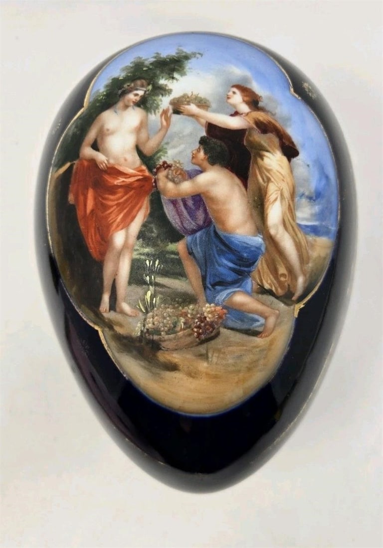 Bohemian Bloch Eichwald Porcelain Egg Box: Hand painted scene on a cobalt blue egg-shaped porcelain box by Bloch Eichwald. Measures approximately 6 1/4 inches tall and wide and is 8 1/2 inches long. There are some chips on the base and on the 