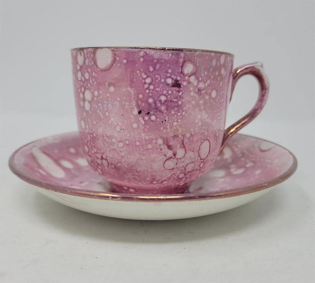 Oil Splash Pink Luster Teacup & Saucer: Staffordshire pink lusterware with oil splash on earthenware. Done in the style of Sunderland Pink Splash. Made from spraying oil on wet luster. Circa early 1800s. There is an indent that might be a m