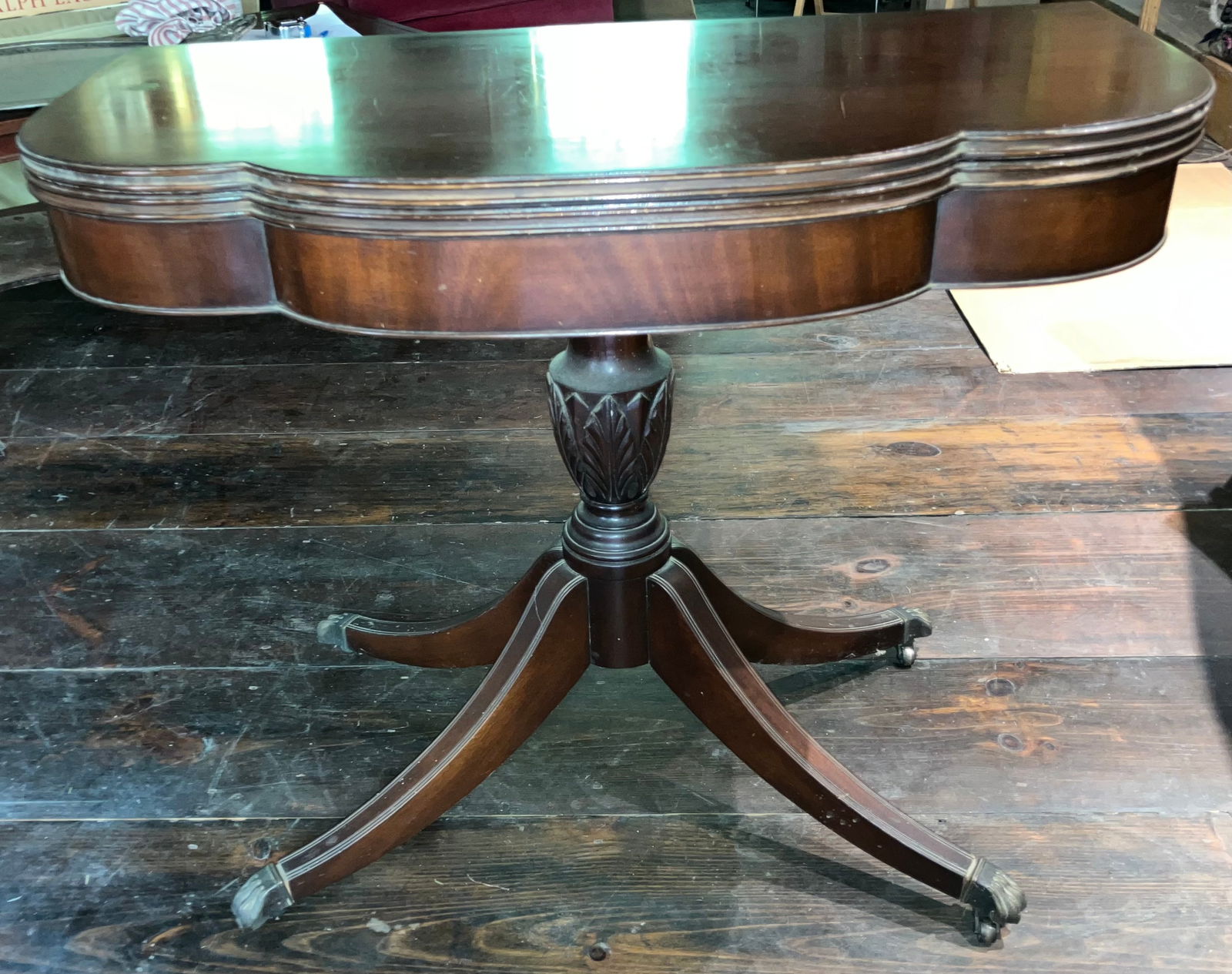 20th Century Duncan Phyfe Style Game Table: Mahogany game table reproduction in the Duncan Phyfe style. It has reeded legs, brass feet and an acanthus leaf carved baluster. It is in fair to good condition. See photos. The dimensions are: 27&rdq