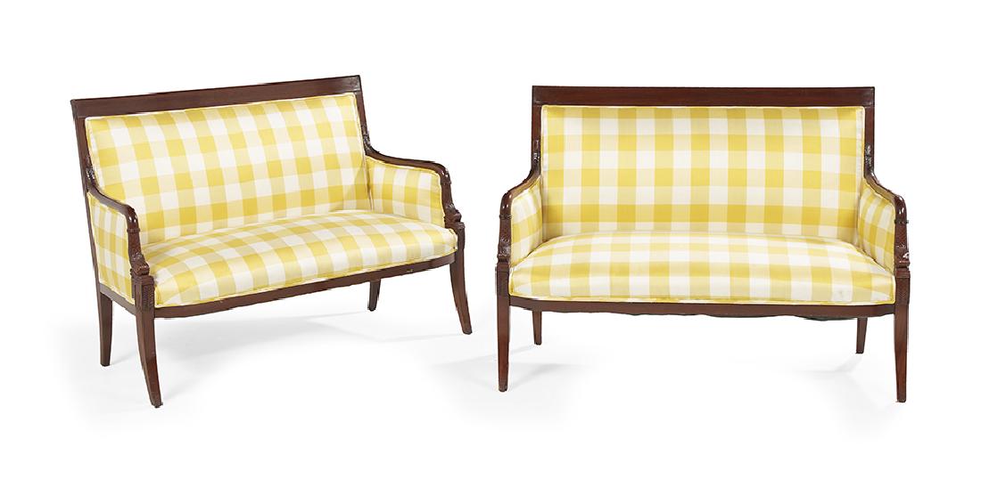 Pair of Restauration-Style Mahogany Settees: Pair of Restauration-Style Mahogany Settees each with a paneled crest above a padded back, joined by closed and padded arms on dolphin uprights to the padded seat, raised on splayed legs. h. 36-1/4",