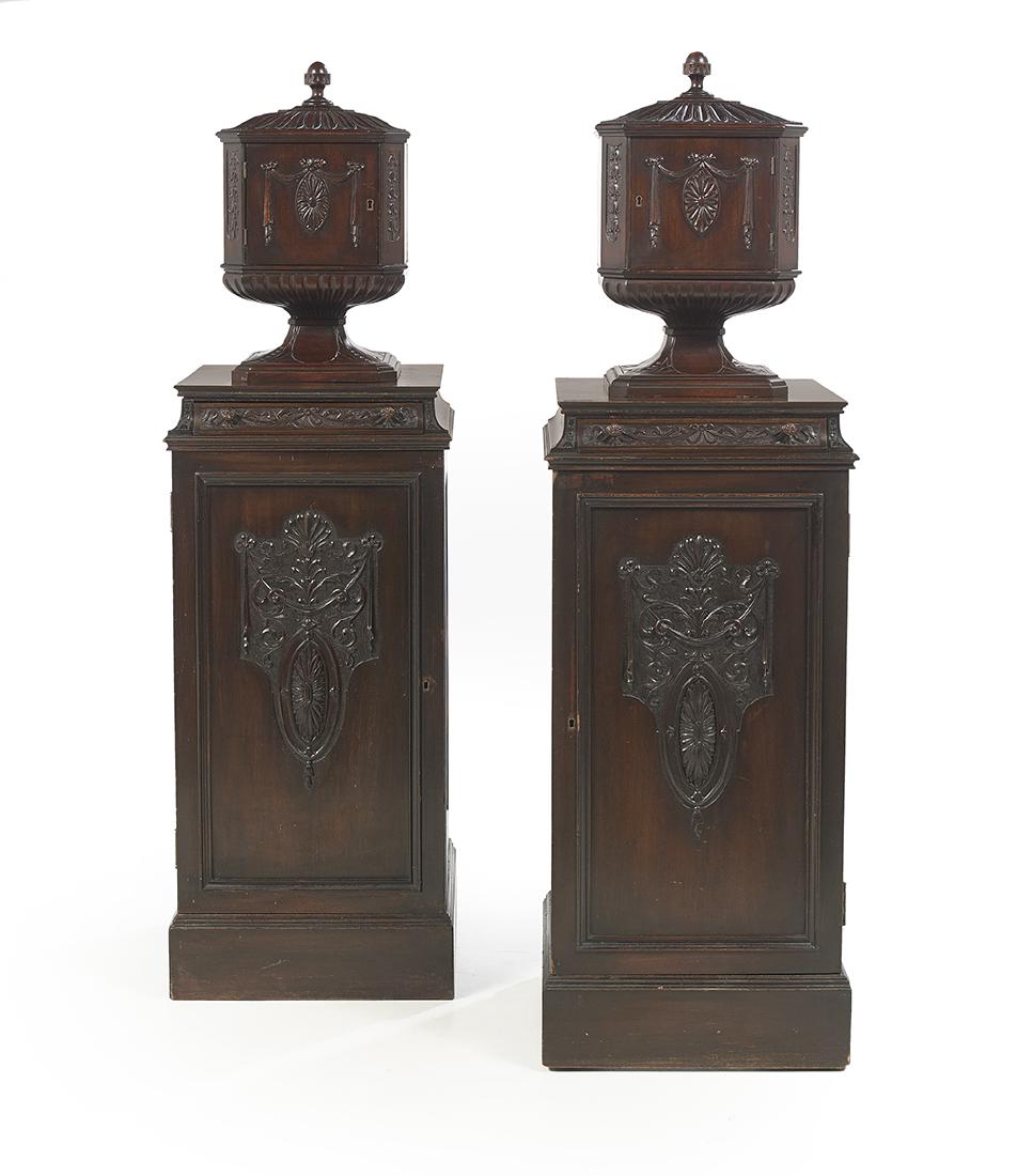 Pair of Regency-Style Mahogany Serving Cabinets: Pair of Regency-Style Mahogany Serving Cabinets 20th century, in the Adam taste, each surmounted by an urn-form cabinet topped by a finial and fitted with a single swag-carved door, opening to four pu