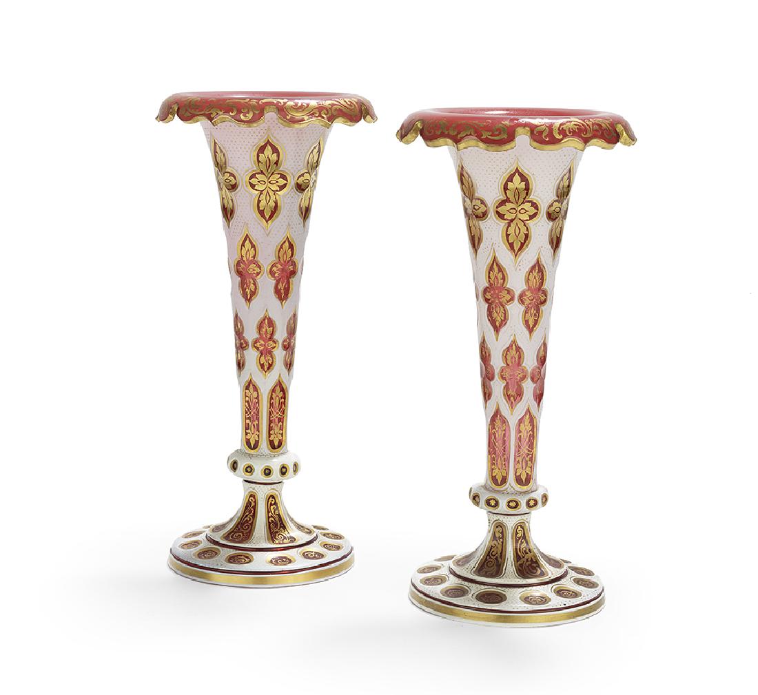 Pair of Bohemian Cased Glass Trumpet Vases: Pair of Bohemian Cased Glass Trumpet Vases third quarter 19th century, composed of cranberry glass cased with opaline, cut with quatrefoils and Gothic panels, trimmed with gilt scrollwork. h. 12-1/2",