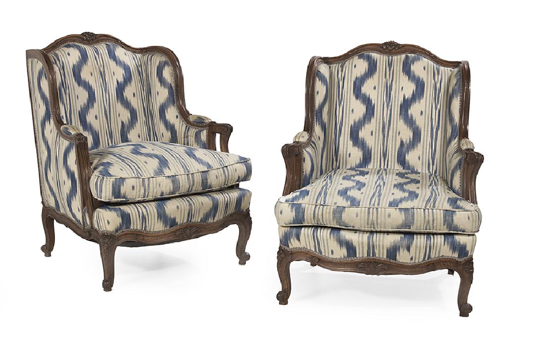 Pair of Louis XV-Style Bergeres avec Orielles: Pair of Louis XV-Style Fruitwood Bergeres avec Orielles early 20th century, each with a domed and padded back surmounted by a floral crest, joined by shaped and padded sides to the cushioned seat, rai