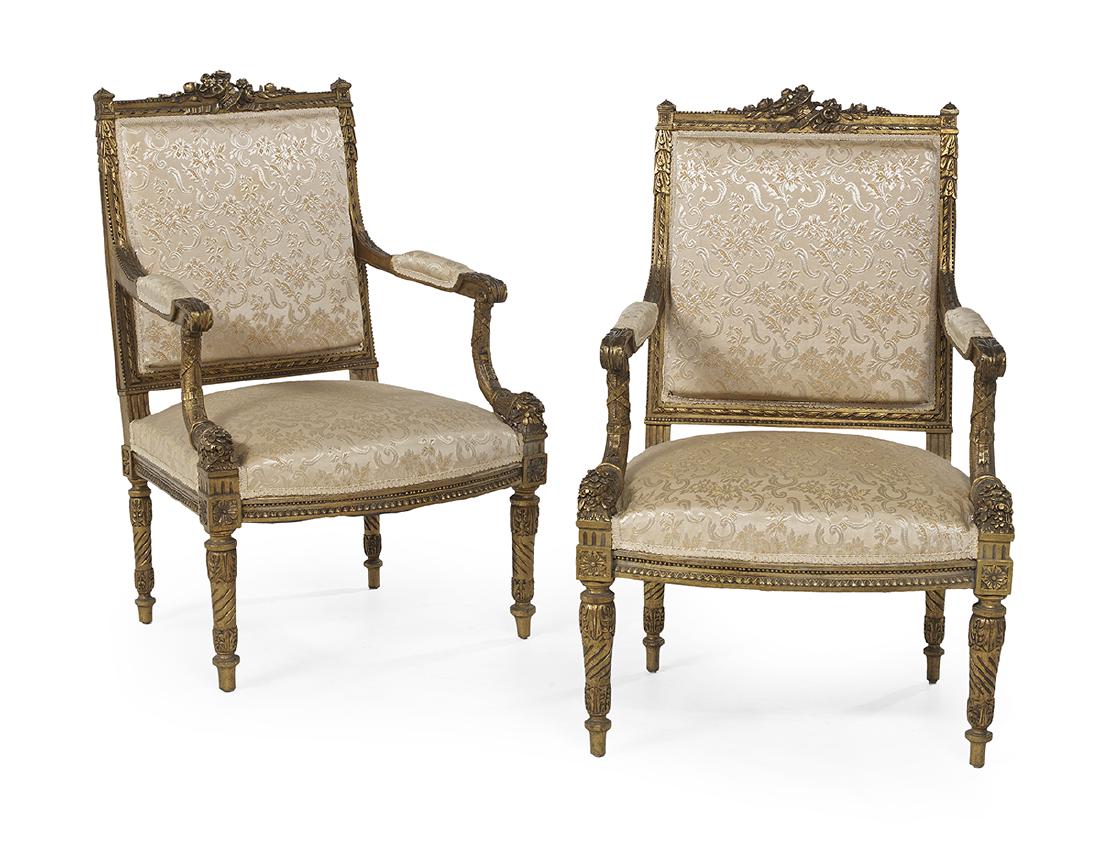 Pair of Louis XVI-Style Giltwood Fauteuils: Pair of Louis XVI-Style Giltwood Fauteuils ca. 1900, each with a foliate-carved trophy chest, open arms on beribboned cornucopia-form supports, and bowed seat rail, raised on foliate-carved and twist-