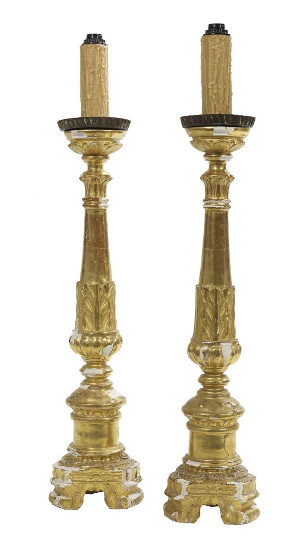 Pair of Neoclassical Giltwood Altar Sticks: Pair of Continental Neoclassical Giltwood Altar Sticks first quarter 19th century, now mounted as lamps, on scrolled feet, the reeded standards carved with lotus leaves, set with tole drip pans. h. 38
