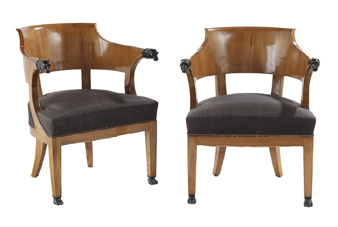 Pair of Charles X Parcel-Ebonized Armchairs: Pair of Charles X Birch and Parcel-Ebonized Armchairs second quarter 19th century, each with a barrel back wrapping to arms terminating in carved dog heads, the tapering front legs terminating in carv