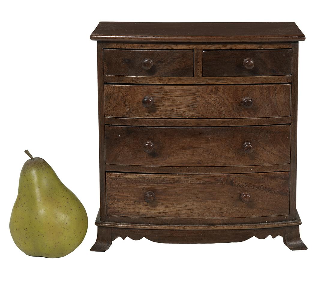 English Miniature Mahogany Bowfront Chest: English Miniature Mahogany Bowfront Chest of Drawers ca. 1900, with turned wooden knobs and French feet flanking a shaped skirt. h. 9", w. 8-1/2", d. 5-1/4" Provenance: Bruce McCashin Collection.