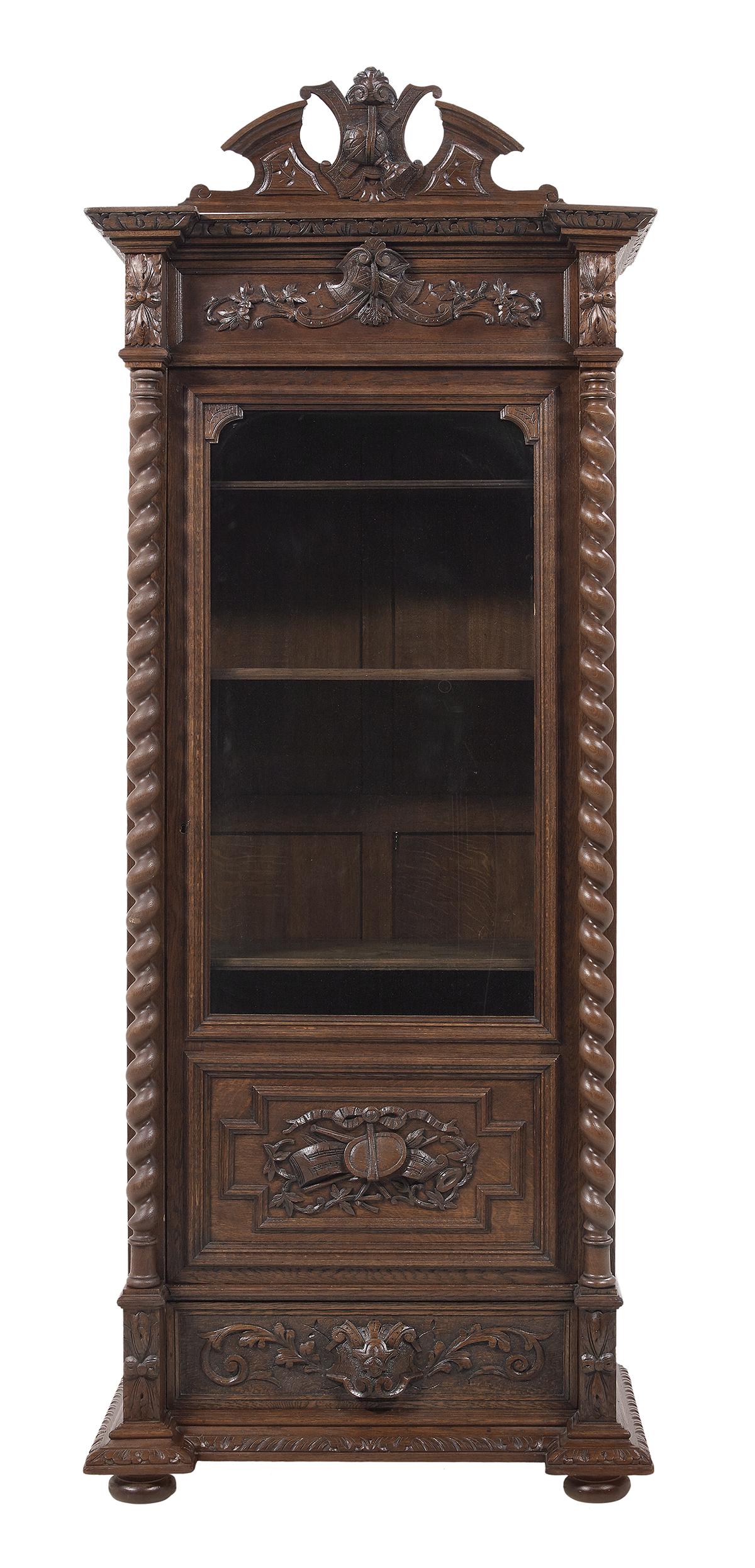 Henri IV-Style Oak Bibliotheque: Henri IV-Style Oak Bibliotheque late 19th century, the carved crest over a molded cornice, the door with a glazed panel over a trophy-carved panel, and flanked by twist-columns, with a drawer below. h