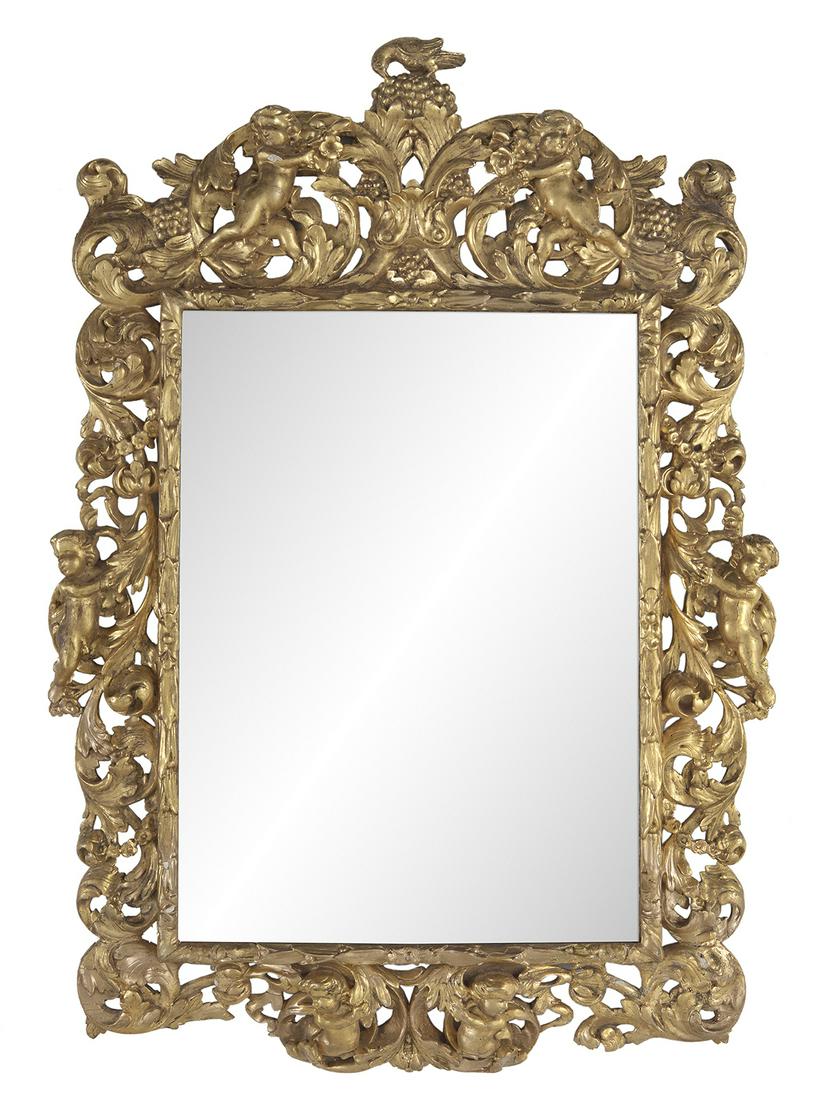 Italian Baroque Giltwood Mirror: Italian Baroque Giltwood Mirror first half 18th century, the pierced surround decorated with scrollwork and leaves, accented with swags of flowerheads, with carved putti on each side and in the grape-