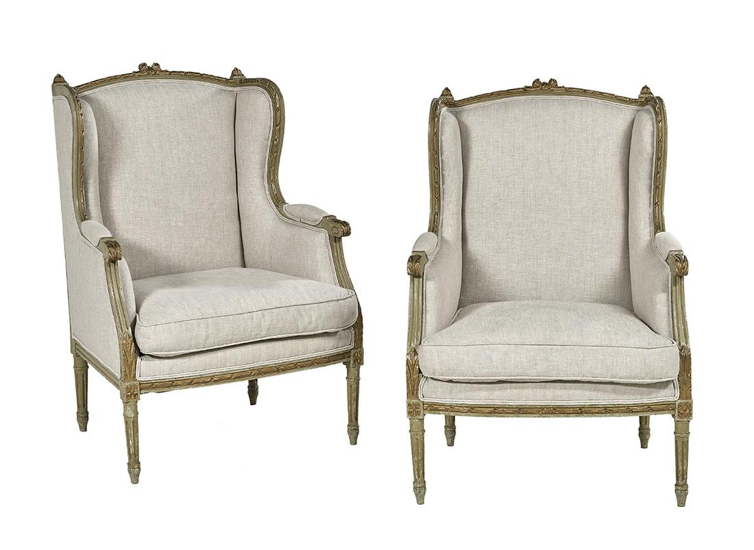 Pair of Louis XVI-Style Polychrome Bergeres: Pair of Louis XVI-Style Polychrome and Parcel-Gilt Bergeres ca. 1900, each wing chair with a floral-carved and ribbon-edged crest rail, extending to closed arms with leaf-carved ends on molded support