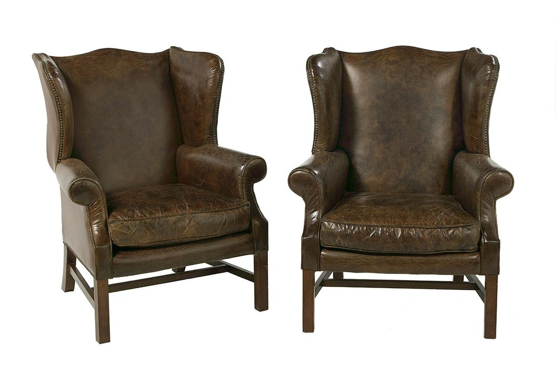 Pair of George III-Style Leather Wing Chairs: Pair of George III-Style Leather Wing Chairs each with shaped wings adorned with brass tacks, joined to scroll arms, a loose seat cushion and square legs joined by an H-form stretcher. h. 41-3/4"