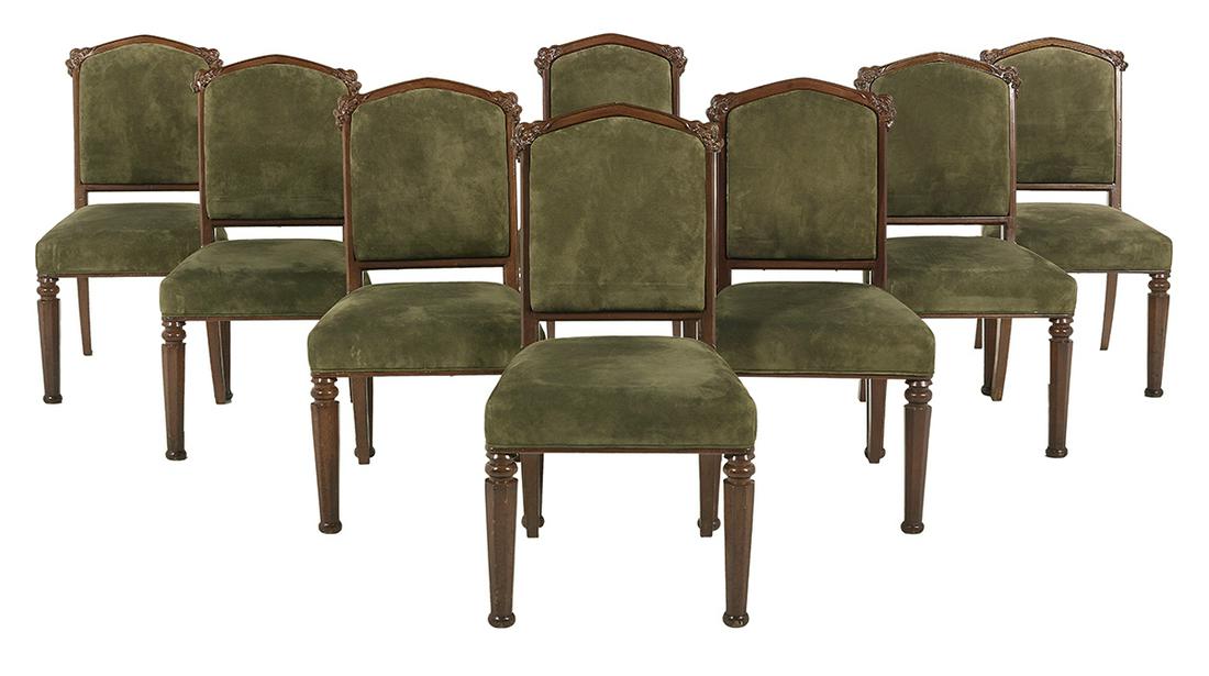 Eight English Gothic Revival-Style Dining Chairs: Suite of Eight English Gothic Revival-Style Mahogany Dining Chairs each with an arched crest rail with leaf carving at the stiles, the seat and back upholstered in forest velvet, raised on octagonal f