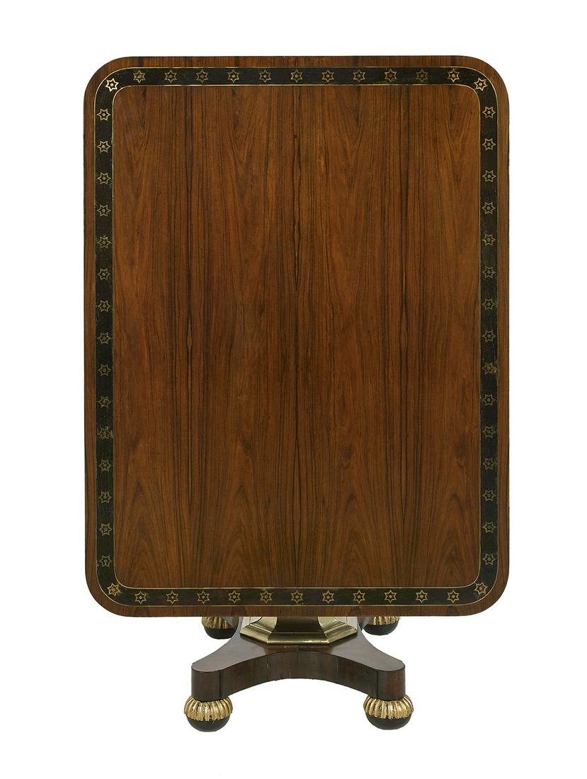 Regency Rosewood and Parcel-Gilt Tilt-Top Table: Regency Rosewood and Parcel-Gilt Tilt-Top Table first quarter 19th century, the rectangular banded and brass-inlaid top over an octagonal pedestal, above a quadruped plinth base ending in reeded bun f