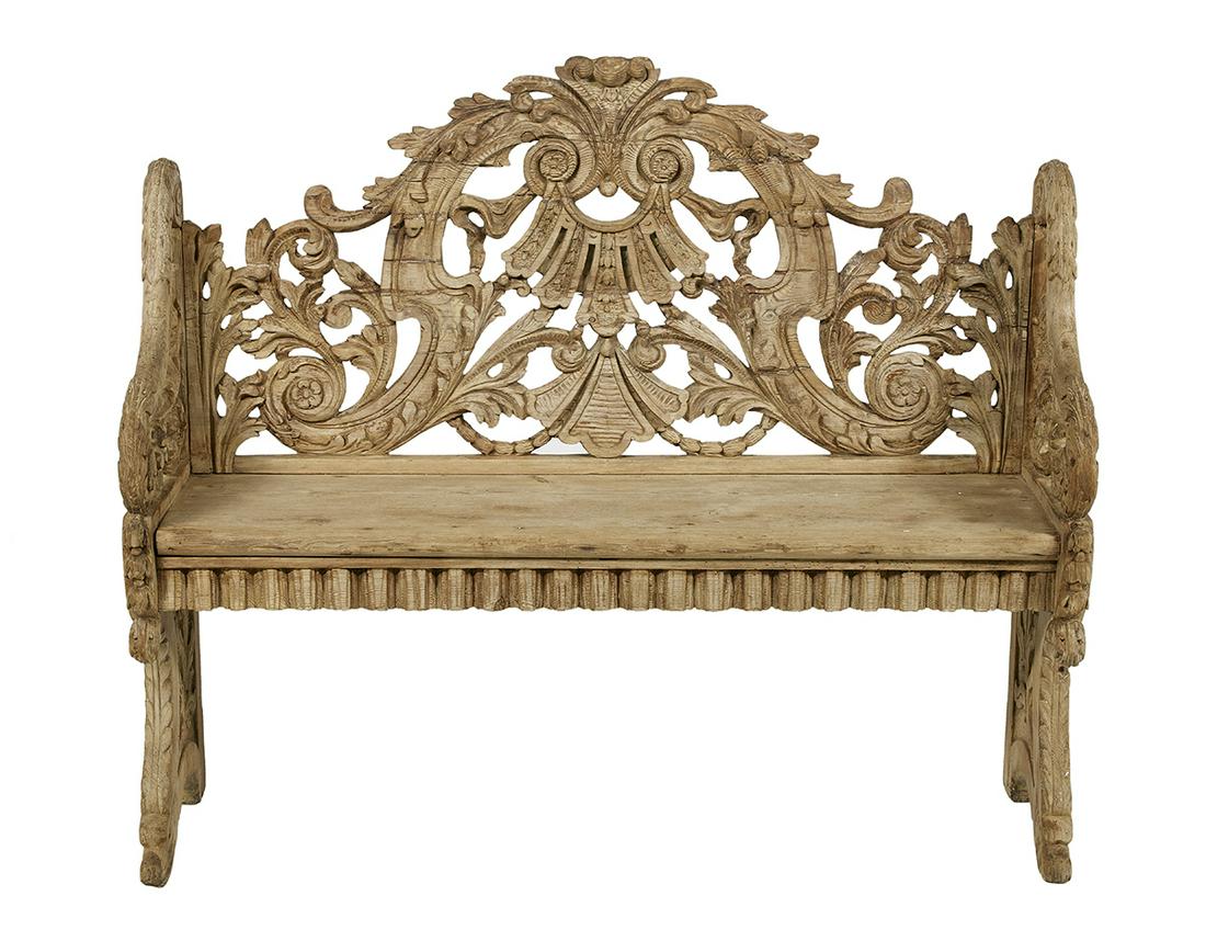Exuberantly Carved Pine Bench: Exuberantly Carved Pine Bench mid-19th century, the scrolling foliate-carved and pierced back joined to the plank seat by acanthine-carved arms, above a dentillated apron, raised on dolphin-carved tre