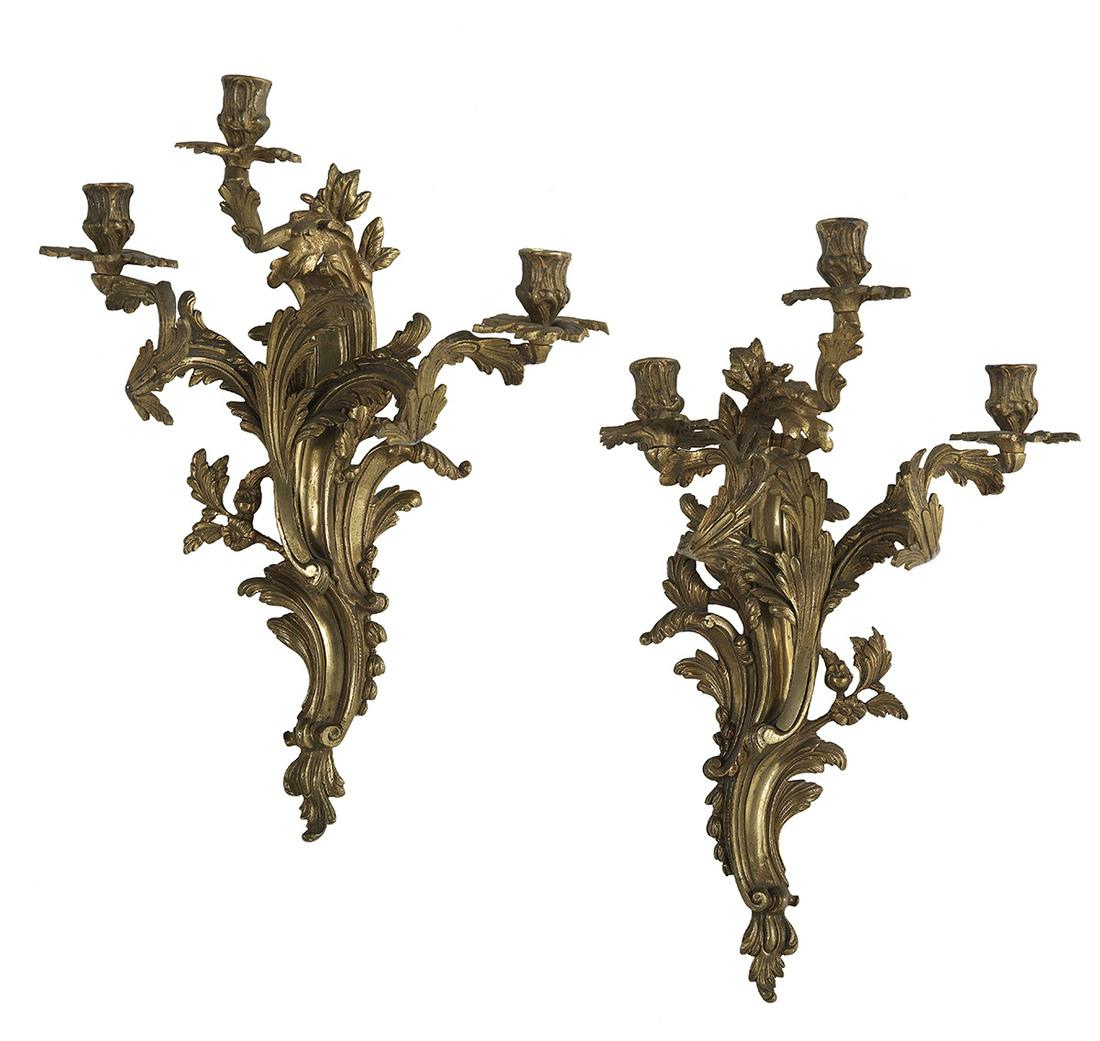 Pair of Louis XV-Style Gilt Bronze Sconces: Pair of Louis XV-Style Gilt Bronze Sconces second half 20th century, French, each having a scrollwork backplate decorated with flowerheads and fitted with a trio of scrolled candle arms. h. 21", w. 13