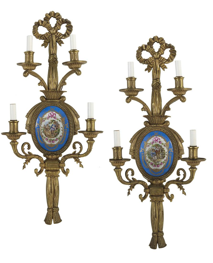 Pair of French Gilt-Bronze and Porcelain Sconces: Pair of French Gilt-Bronze and Porcelain Sconces 20th century, in the Louis XVI taste, each with a bowknot and tassels backplate, and decorated with a bleu-celeste-ground porcelain oval plaque with a 