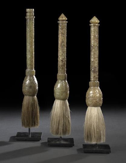 Group of Three Chinese Calligraphy Brushes: Group of Three Chinese Mounted Calligraphy Brushes, each with a carved mottled green serpentine handle decorated in low relief with hydra serpents and archaic symbols, mounted on custom black steel st