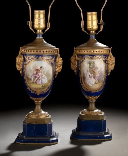 Pair of French Brass-Mounted Porcelain Vases: Pair of French Gilt-Brass-Mounted Bleu-de-Roi Porcelain Two-Handled Garniture Vases, first quarter 20th century, in the Louis XVI Sevres style, the handles modeled as gilt-brass ram masques, each faca