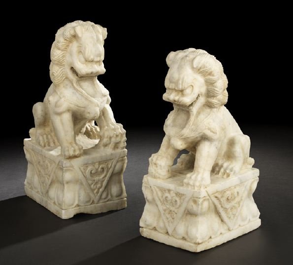 Pair of Kuang Hsu White Marble Foo Dogs: Large Pair of Kuang Hsu Carved White Marble Figures of Foo Dogs, first quarter 20th century, depicted seated on integral draped pedestals in the Ming Dynasty style, h. 21", w. 8", d. 10".