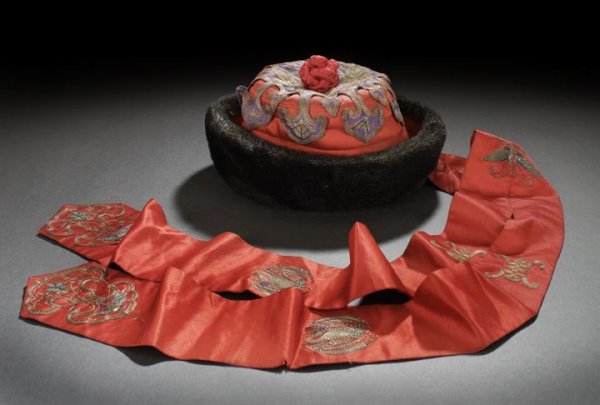 Chinese Child's "Mandarin" Hat: Chinese Child's "Mandarin" Hat, 20th century, modeled after an adult's court hat in red silk with fur trim, with embroidered ruyi decoration, red silk top knot and red silk streamers with embroidered 
