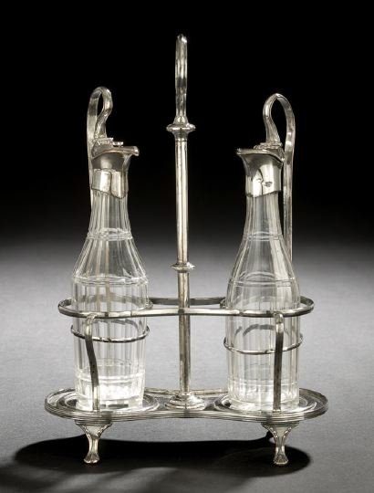 Continental Silverplate Cruet Frame: Continental Silverplate Cruet Frame, second quarter 19th century, in the neoclassical taste, the waisted oval frame raised on four shell pad feet, with a conforming wirework frame flanking a central k