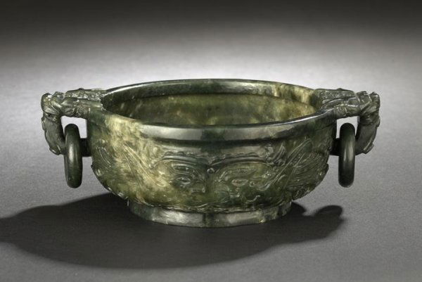 Chinese Carved Jade Two-Handled Bowl: Chinese Carved Jade Two-Handled Bowl, 19th century, of circular form with flattened lip rim, monster-head handles and loose rings, the exterior carved in low relief with confronting phoenix birds form