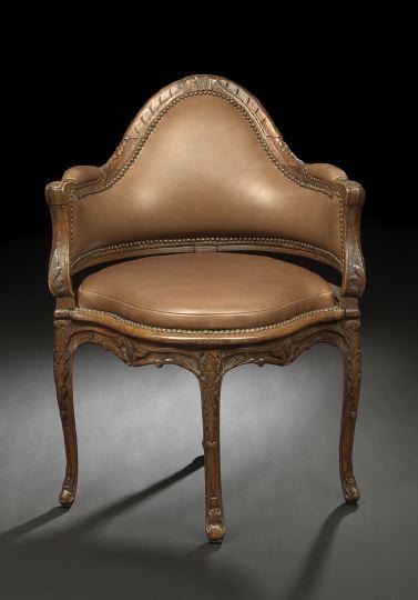 Provincial Louis XV-Style Bergere en Encoignure: Provincial Louis XV-Style Fruitwood Bergere en Encoignure, mid-19th century, the steep domed and padded back surmounted by a floral- and foliate-carved crest, joined to the padded seat by downswept pa