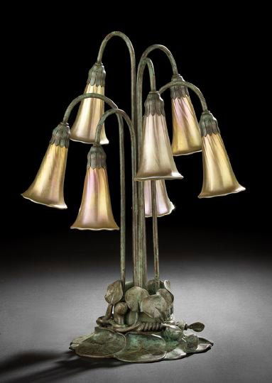 American Bronze Seven-Light "Lily" Table Lamp: American Patinated Bronze Seven-Light "Lily" Table Lamp, in the Art Nouveau style of the Tiffany Studios, New York, each light fitted with an iridescent ribbed glass floriform shade signed in script "