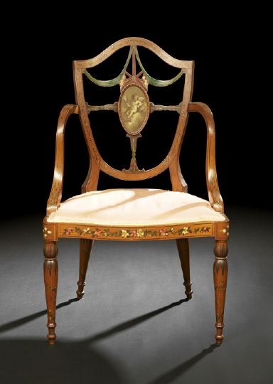 Edwardian Satinwood Armchair: Edwardian Satinwood Armchair, ca. 1900, in the Hepplewhite taste, the shield-form back centered by an oval panel of a painted cherub, joined by high downswept arms to the cushioned seat, raised on tap