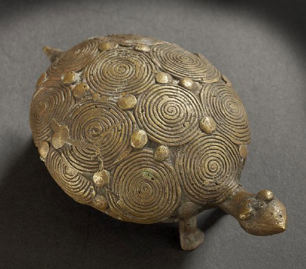 Akan Ashanti Turtle-Form Gold Weight: Akan Ashanti Turtle-Form Gold Weight, cast as a standing figure of a turtle on four legs with outstretched head, the carapace cast as a series of coiled circles with scattered bosses, h. 2-1/8", l. 5-