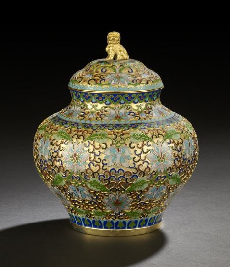 Chinese Champleve Covered Urn: Chinese Champleve Covered Urn, 20th century, the squat bulbous body with conforming cover surmounted by a Foo-dog finial, the gilded body with champleve enamel decoration of lotus blossoms and foliage