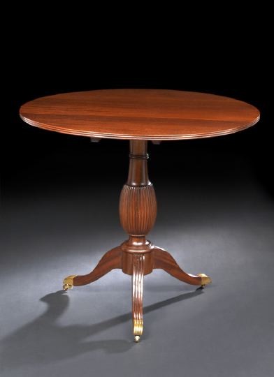 Victorian Mahogany Tripod Table: Victorian Mahogany Tripod Table, fourth quarter 19th century, the circular tilting top raised on a reeded and bulbous standard to three splayed and reeded legs ending in brass caps on casters, h. 31-3