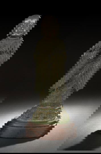 Chinese Cast-Bronze Figure of a Lohan: Chinese Cast-Bronze Figure of a Lohan, Ming Dynasty (1368-1644), cast as a standing figure with bald pate, elongated earlobes and dressed in brocade-trimmed robes on a lotus base with clasped hands, p