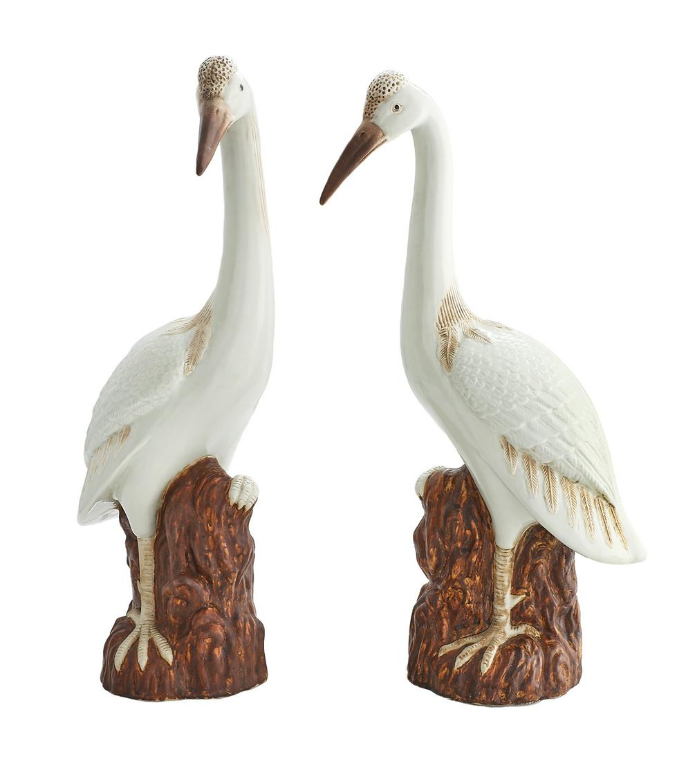 Pair of Porcelain Cranes: Pair of Porcelain Cranes 20th century, the white-glazed birds with molded feathers and brown accents, poised standing on a rocky outcropping. h. 21-1/4", w. 5-1/4", d. 10"