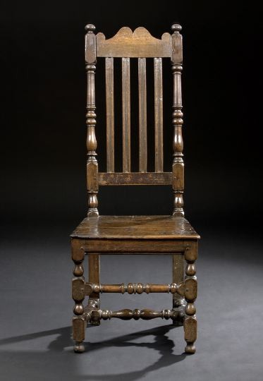 English Carved Oak Hall Chair: English Carved Oak Hall Chair, mid-19th century, in the Jacobean taste, the scalloped crest flanked by ball finials and over three reeded splats flanked by turned uprights, the wooden seat raised on t