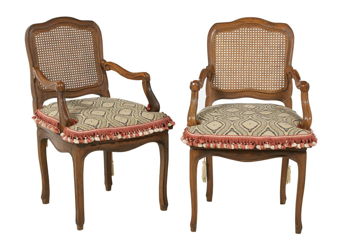 Pair of French Provincial Fruitwood Fauteuils: Pair of French Provincial Fruitwood Fauteuils 19th century, each with a shaped and caned back joined by scrolling arms to the cushioned and caned seat, raised above a molded and shaped frieze on cabri