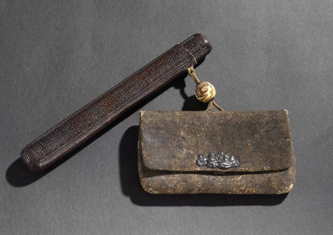 Japanese Bamboo and Metal Pipe and Tobacco Pouch: Japanese Sheathed Bamboo and Metal Pipe and Tobacco Pouch, 19th century, composed of a bamboo pipe with white metal fittings enclosed in a textured leather holder and attached with a silk cord and ivo
