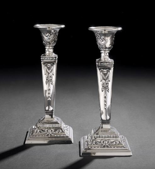Pair of Edwardian Silverplate Candlesticks: Pair of Edwardian Silverplate Candlesticks, first quarter 20th century, in the Adam taste, of tapering concave square section, with an inverted bell-shaped nozzle and cavetto-domed square base, the wh